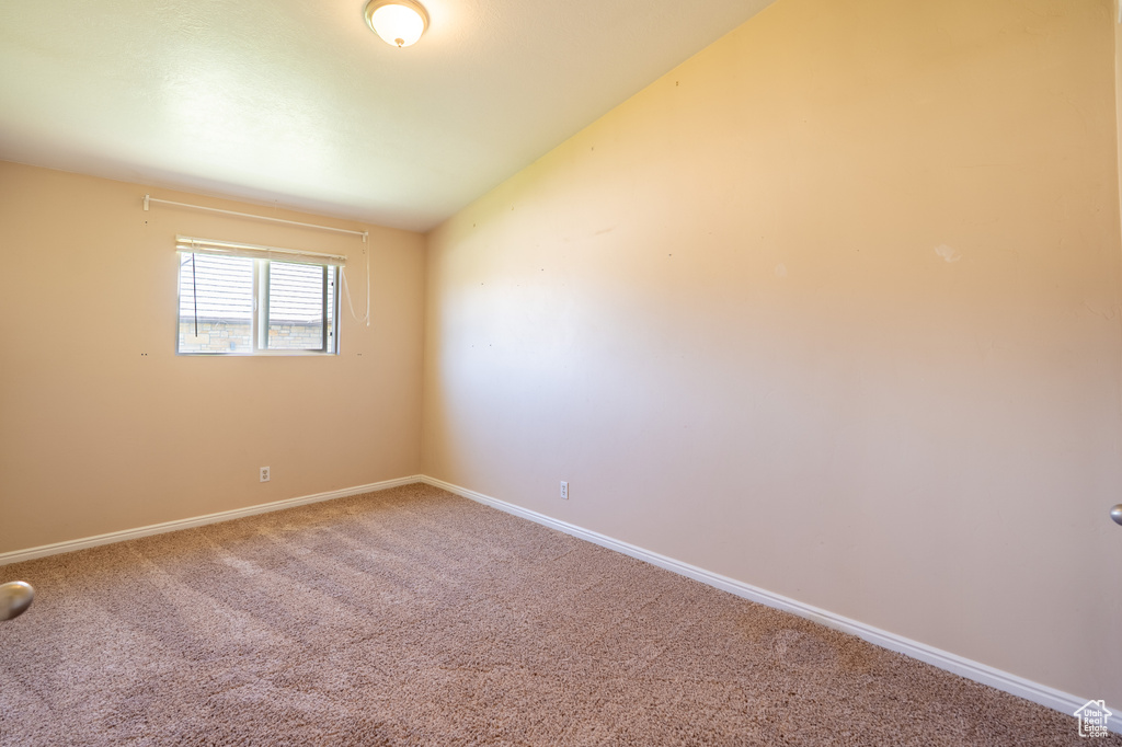 Carpeted empty room featuring baseboards