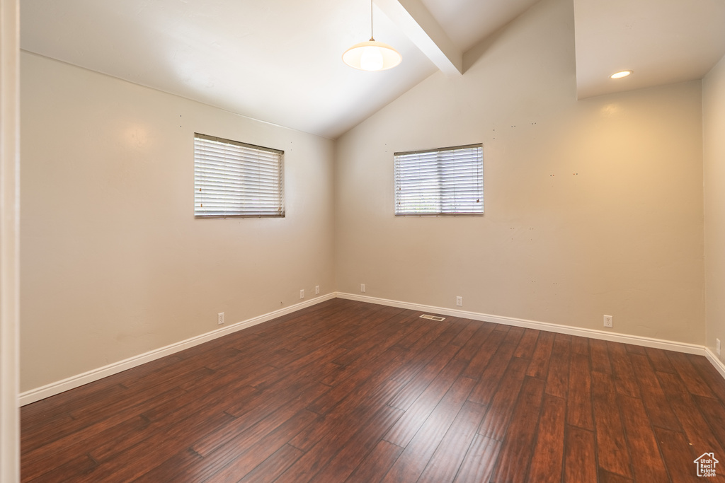 Empty room featuring dark wood-style floors and baseboards