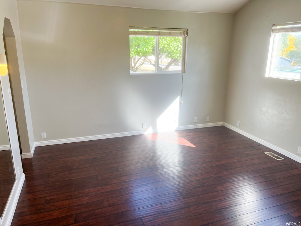 Spare room featuring dark hardwood floors