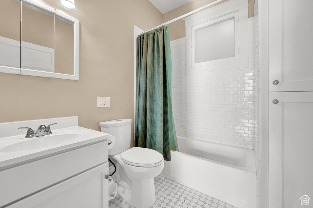 Full bathroom with shower / tub combo with curtain, toilet, vanity with extensive cabinet space, and tile flooring