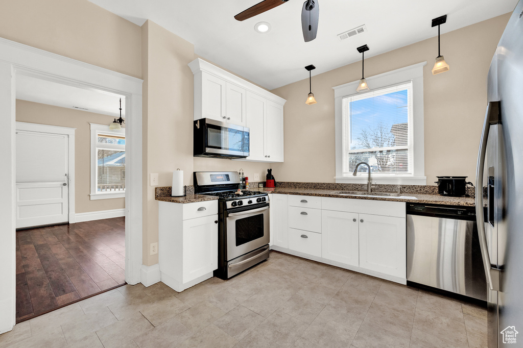 Kitchen with sink, stainless steel appliances, light tile floors, and ceiling fan