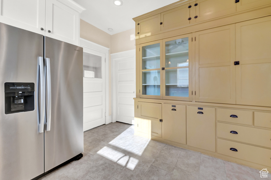 Kitchen with stainless steel refrigerator with ice dispenser and light tile floors