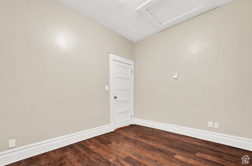 Empty room featuring vaulted ceiling and dark hardwood / wood-style floors