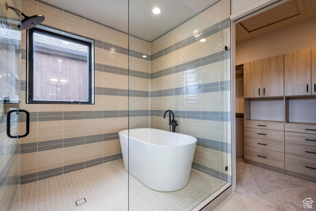 Bathroom featuring tile flooring, independent shower and bath, and tile walls