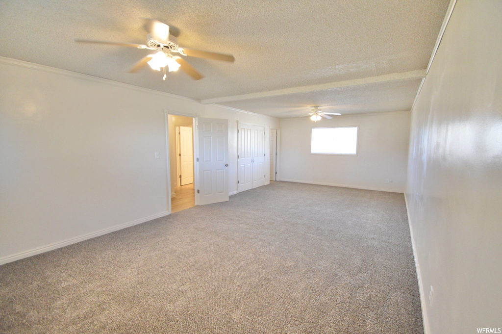 Unfurnished room featuring ceiling fan, light carpet, and a textured ceiling