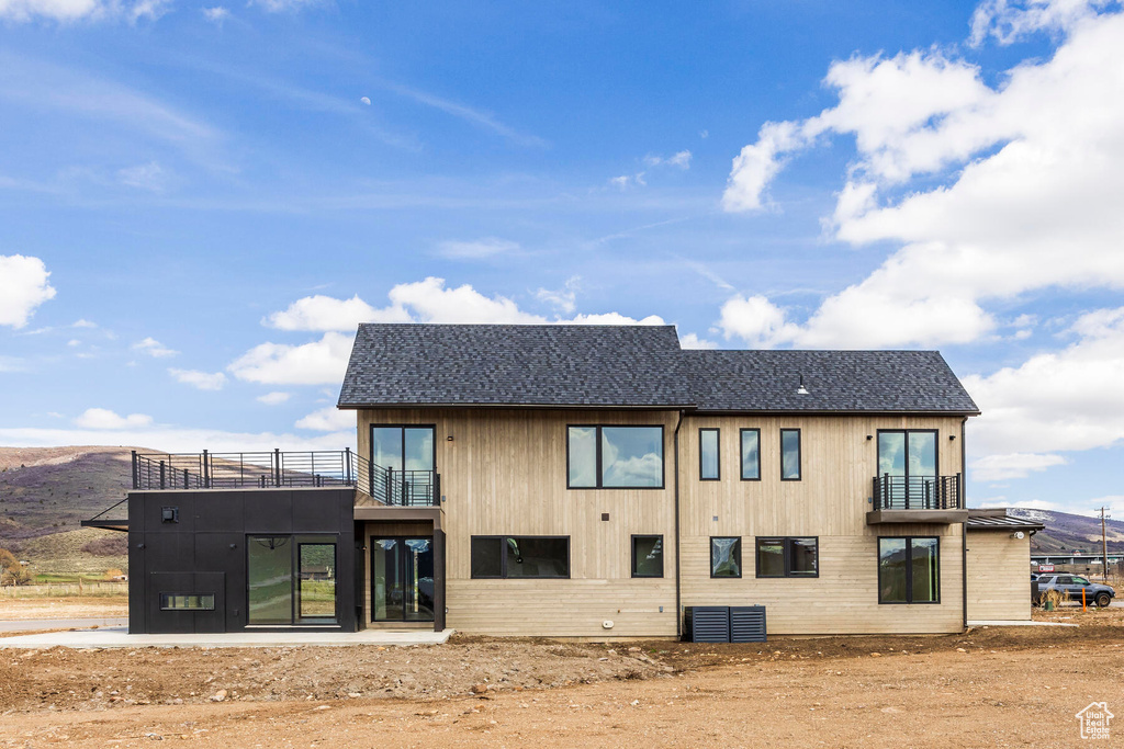 Rear view of house with a mountain view and a balcony