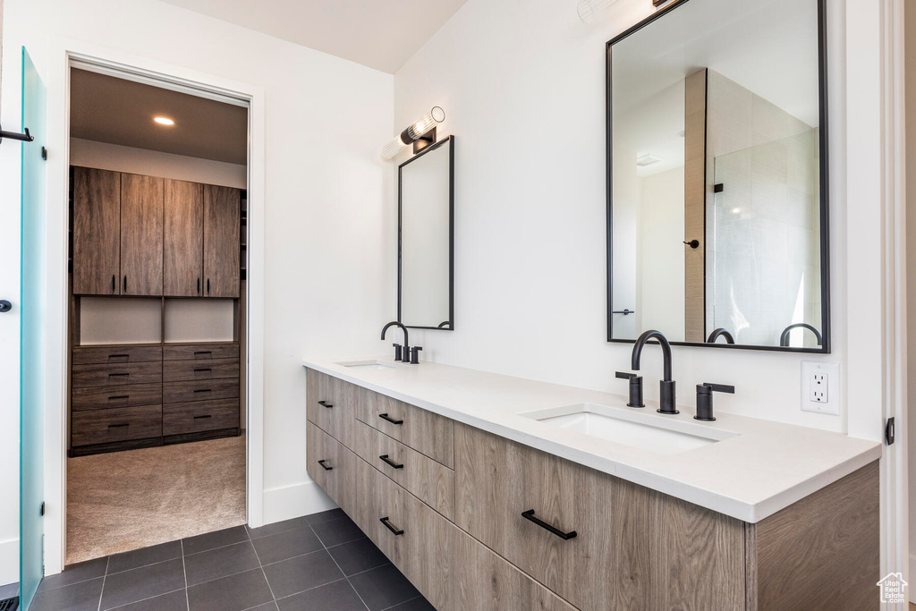Bathroom featuring large vanity, tile floors, and dual sinks