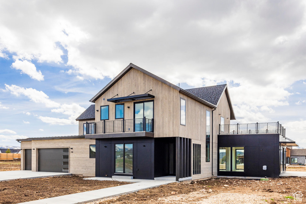 View of front of home with a balcony and a garage