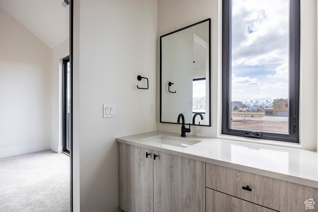 Bathroom with a mountain view, vanity, and vaulted ceiling