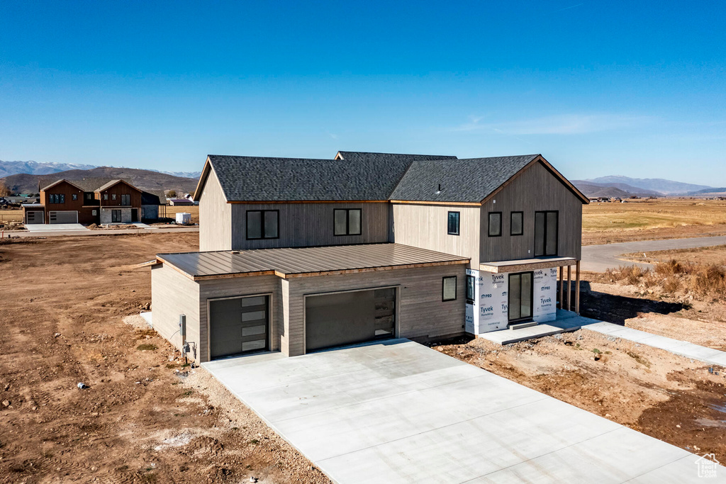 View of front of home with a mountain view and a garage