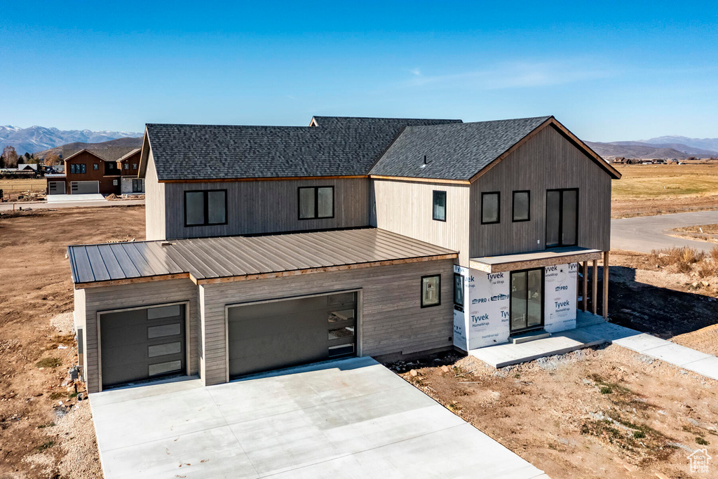 Modern farmhouse with a garage and a mountain view