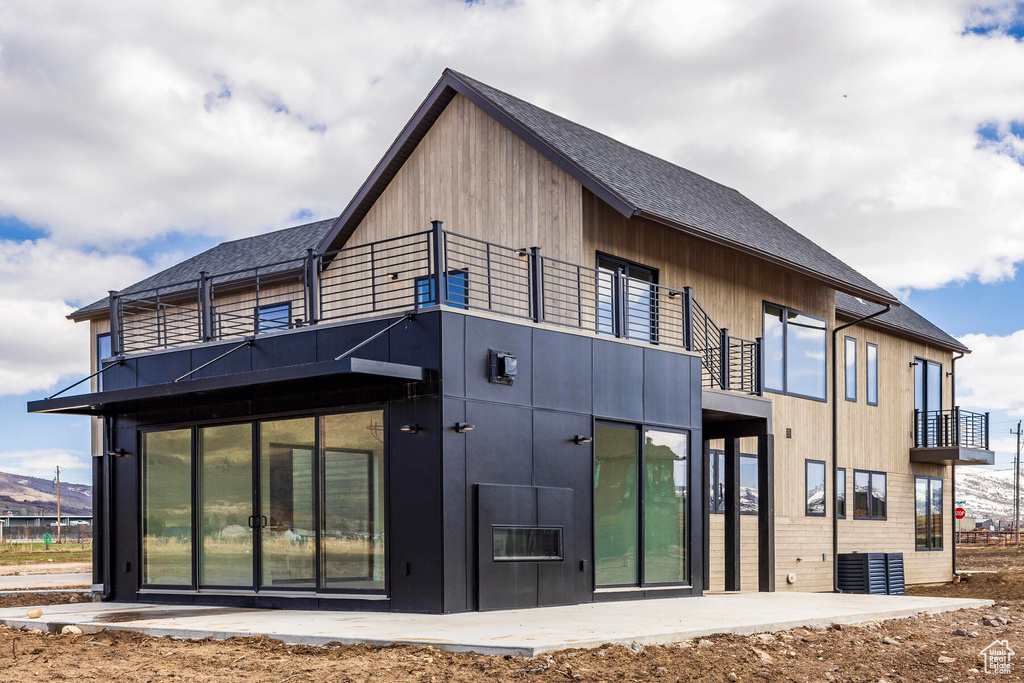 Rear view of property with a balcony and a patio area