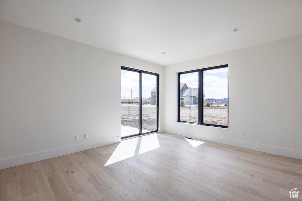 Empty room with light hardwood / wood-style flooring