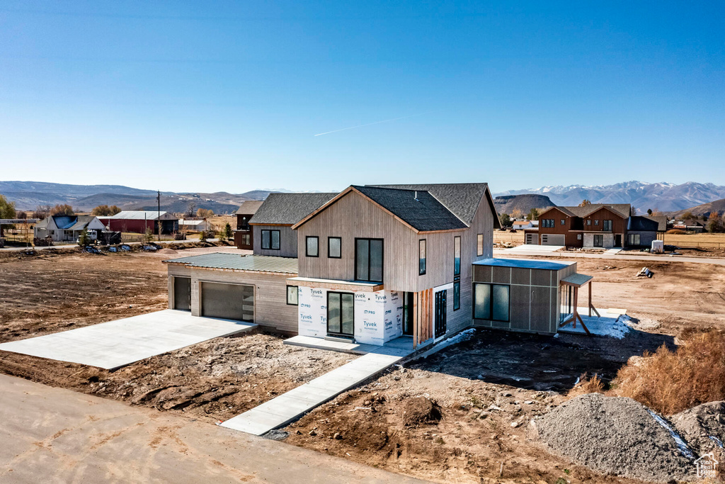 View of front facade with a mountain view and a sunroom