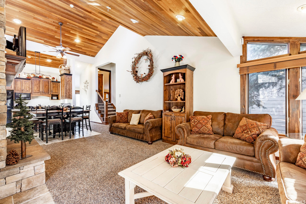 Living room with high vaulted ceiling, ceiling fan, and wood ceiling