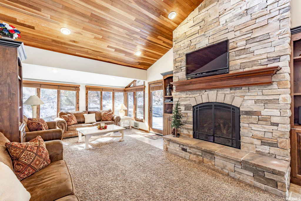 Carpeted living room featuring high vaulted ceiling, a fireplace, and wood ceiling