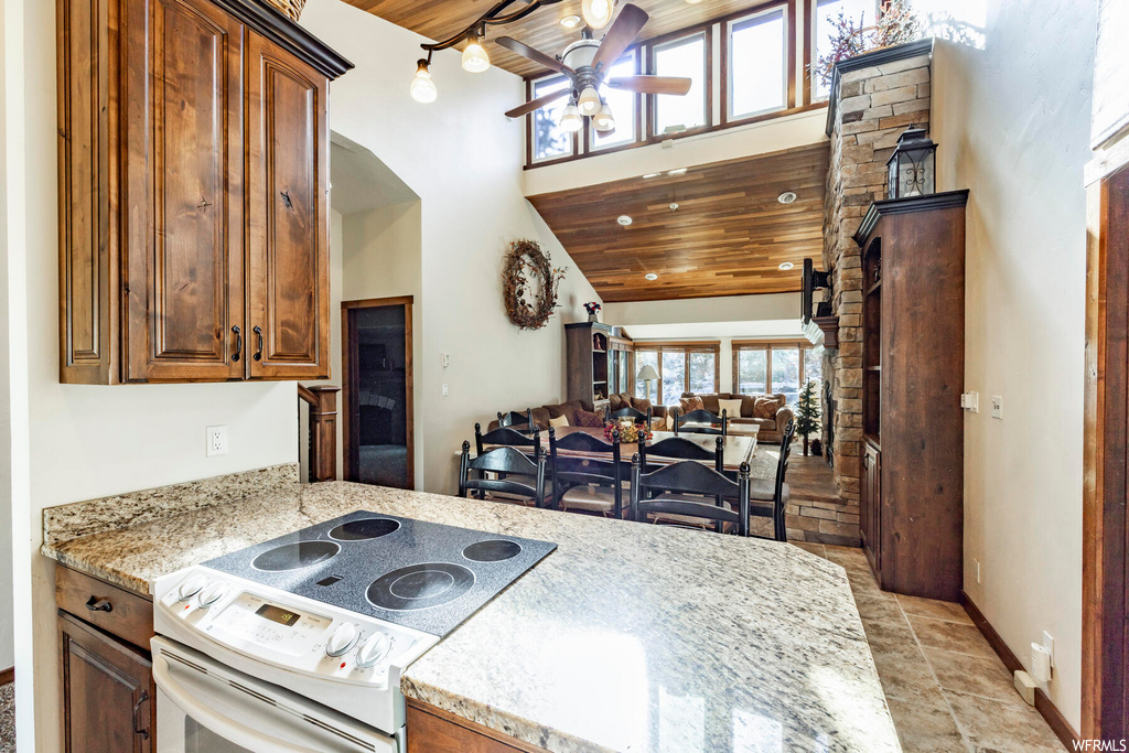Kitchen featuring high vaulted ceiling, white electric stove, ceiling fan, and wooden ceiling