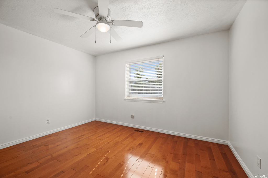 Empty room featuring ceiling fan and wood-type flooring