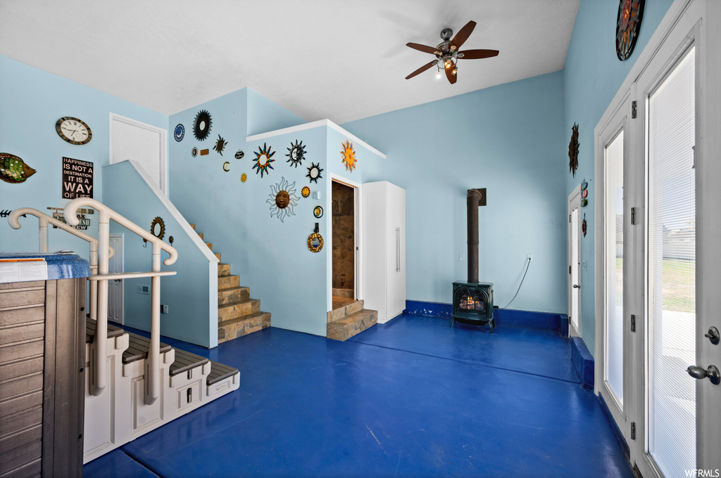 Miscellaneous room with a wood stove and ceiling fan