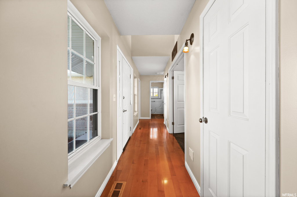 Hallway with dark hardwood / wood-style floors