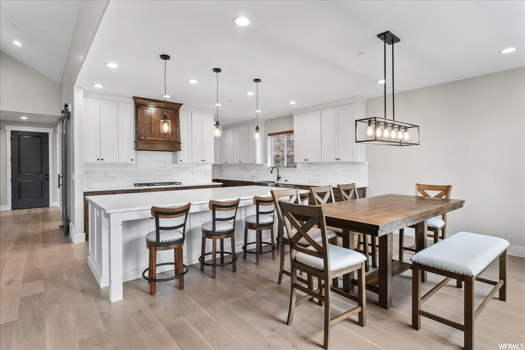 Dining space with light hardwood / wood-style floors, a chandelier, and sink