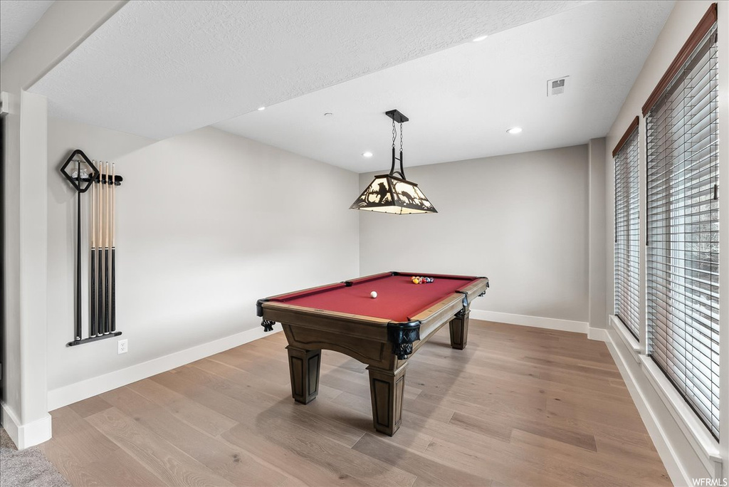 Game room with billiards and light wood-type flooring