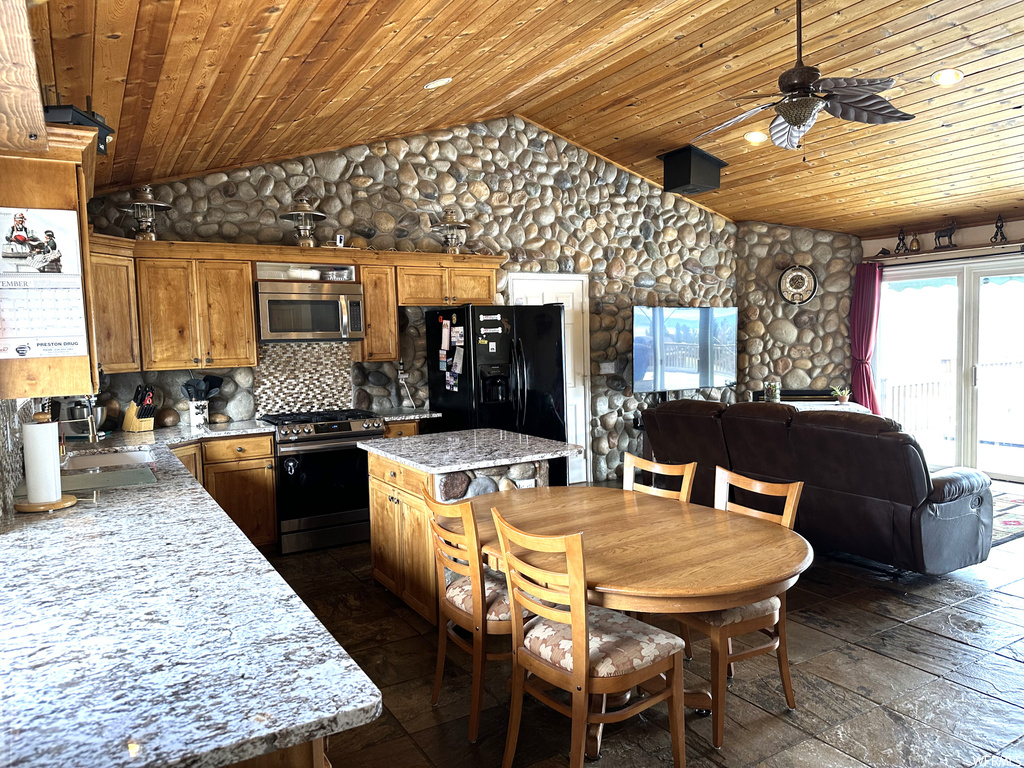 Kitchen featuring a kitchen island, ceiling fan, tasteful backsplash, range, and wooden ceiling