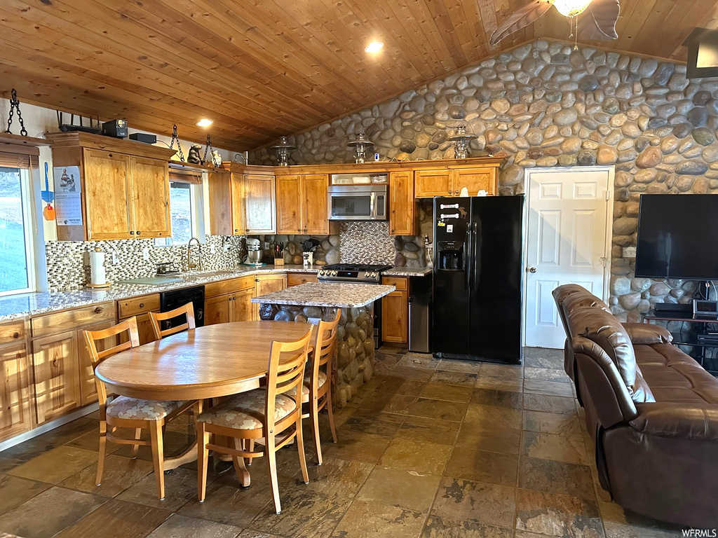 Kitchen featuring tasteful backsplash, a center island, dark tile floors, lofted ceiling, and wooden ceiling