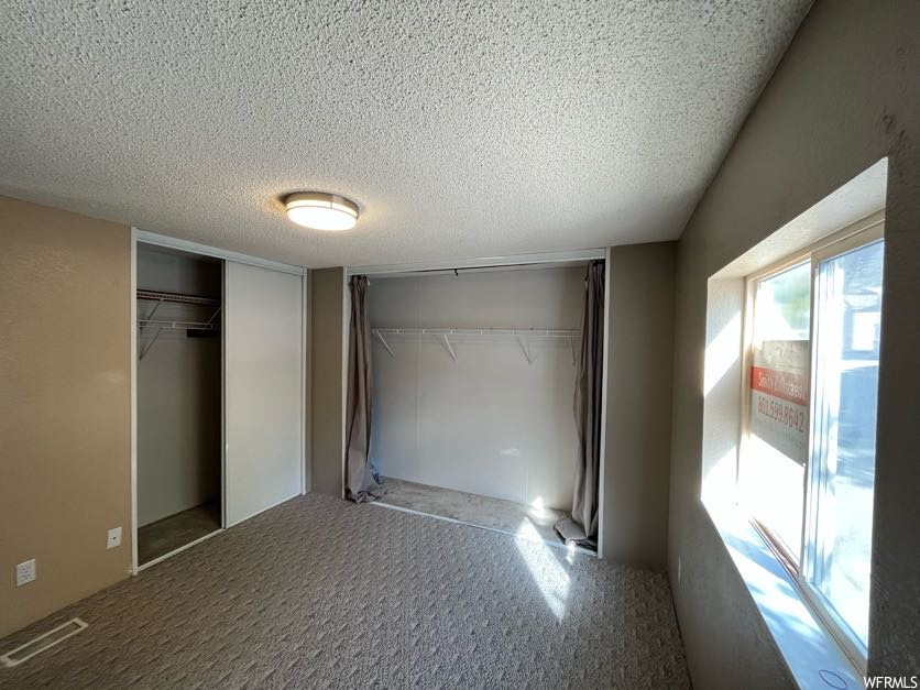 Unfurnished bedroom with a textured ceiling and carpet flooring
