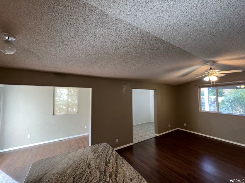 Spare room with ceiling fan, wood-type flooring, and a textured ceiling
