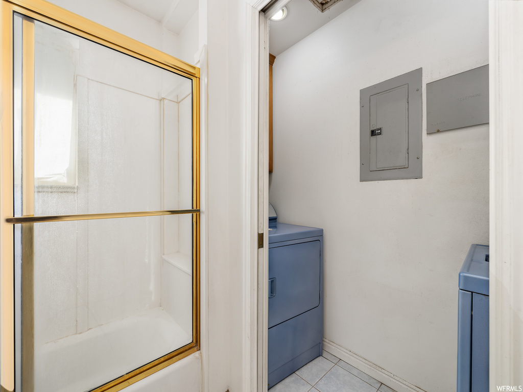 Bathroom featuring washer / clothes dryer, tile flooring, and shower / bath combination with glass door
