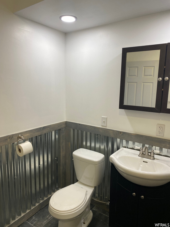 Bathroom featuring toilet, vanity, and tile floors