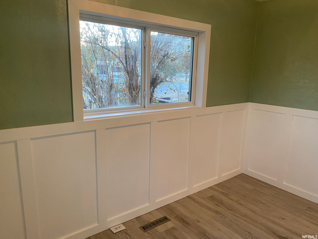 Spare room featuring a wealth of natural light and light wood-type flooring