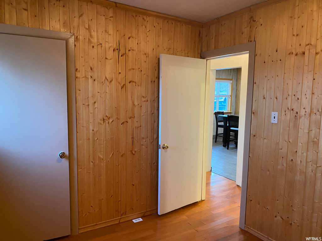 Corridor featuring light hardwood / wood-style floors and wood walls