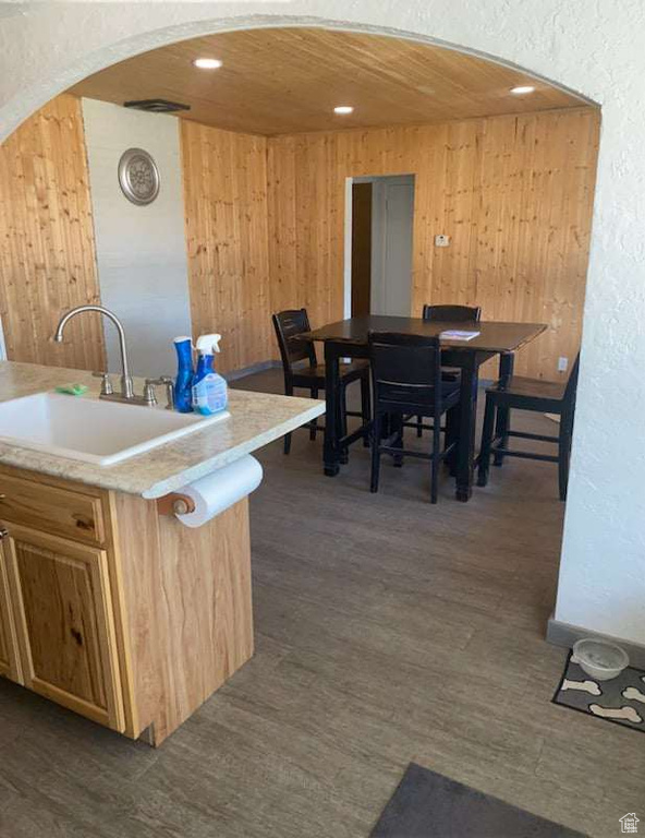 Kitchen featuring sink, dark hardwood / wood-style floors, and wooden walls