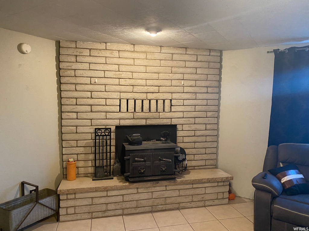 Tiled living room featuring a fireplace and brick wall