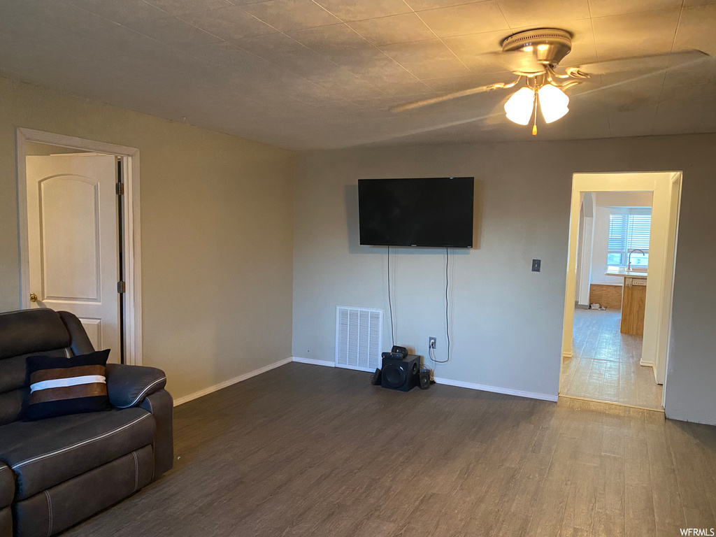 Living room featuring ceiling fan and hardwood / wood-style flooring