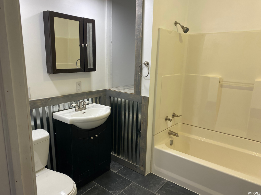 Full bathroom featuring tile floors, toilet, washtub / shower combination, and oversized vanity