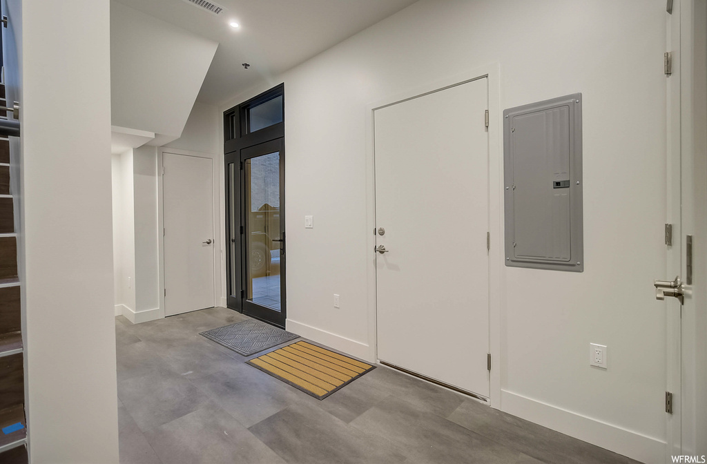 Foyer entrance with concrete flooring and lofted ceiling