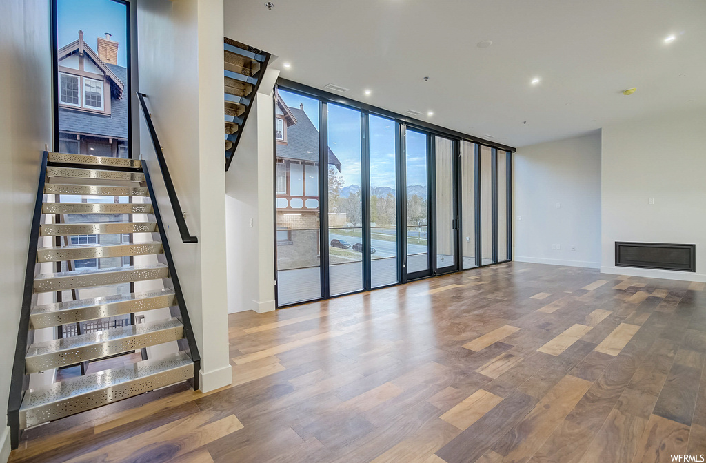 Interior space with a wall of windows and light hardwood / wood-style flooring