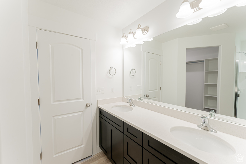 Bathroom featuring double sink and vanity with extensive cabinet space