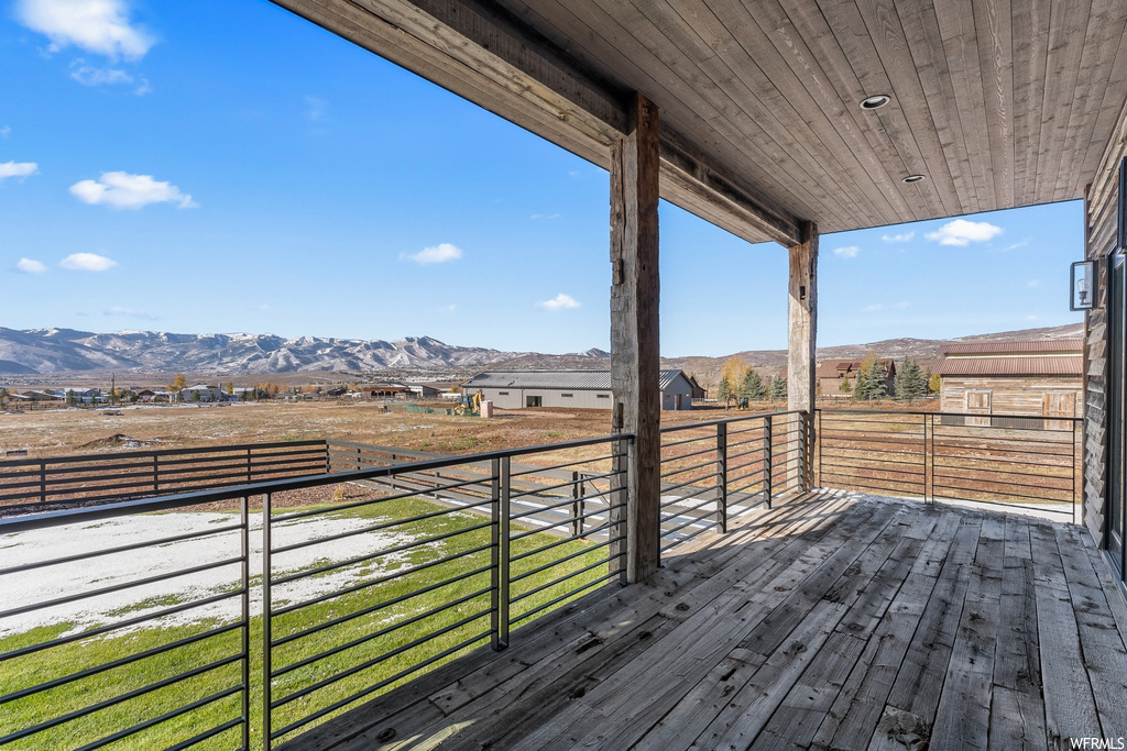 Wooden deck with a yard and a mountain view
