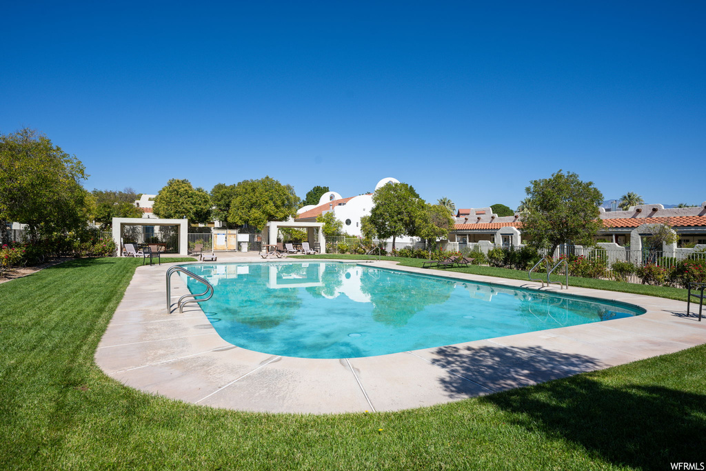 View of swimming pool featuring a yard and a patio