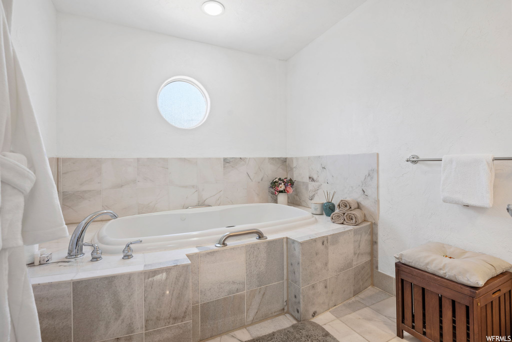 Bathroom featuring tile flooring and a relaxing tiled bath