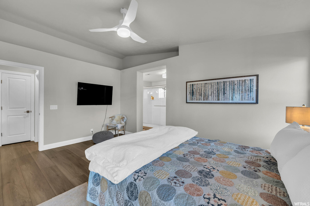 Bedroom with ceiling fan, ensuite bathroom, and dark hardwood / wood-style floors