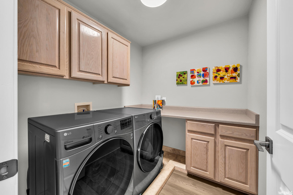 Laundry room featuring washer hookup, light wood-type flooring, cabinets, and independent washer and dryer