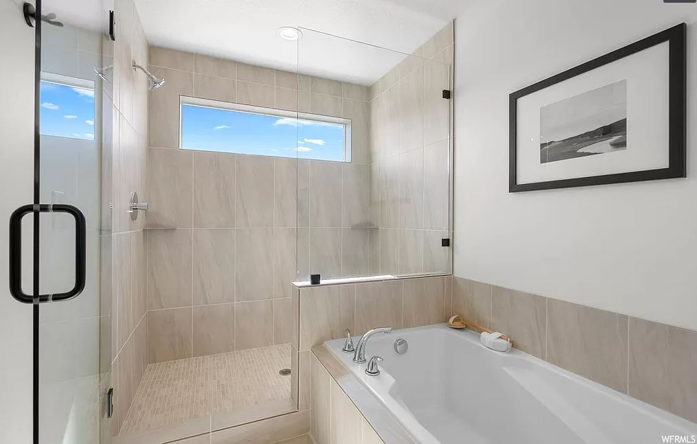 Bathroom with a wealth of natural light and shower with separate bathtub
