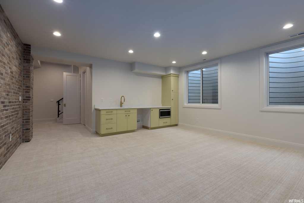 Basement with light colored carpet and sink