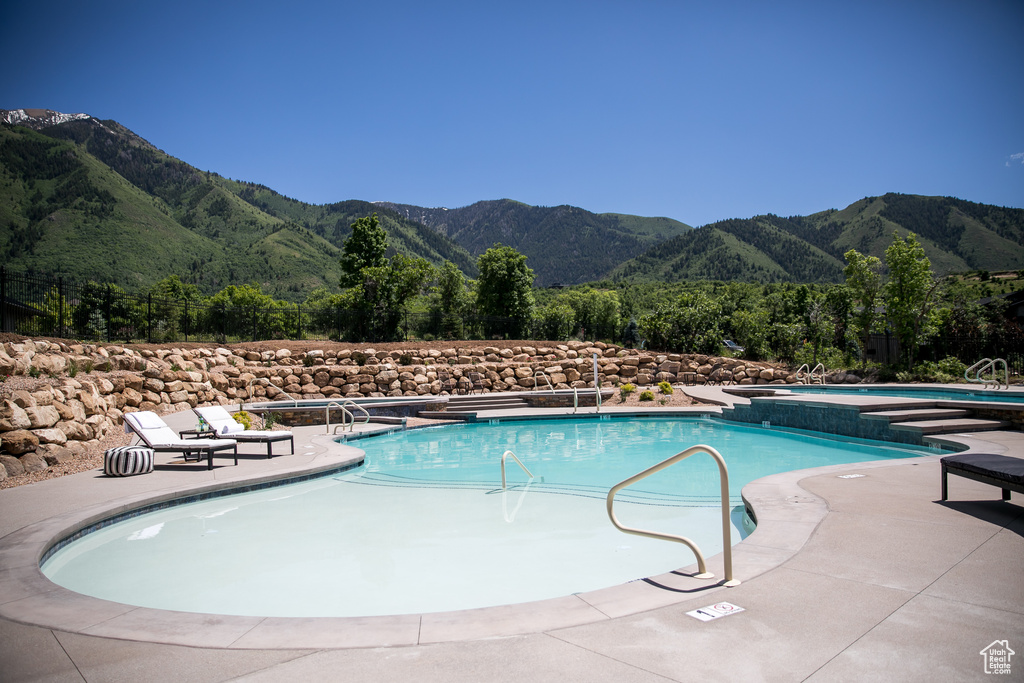 View of swimming pool with a mountain view and a patio area