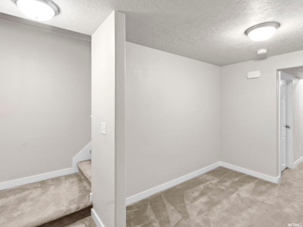 Carpeted empty room featuring a textured ceiling